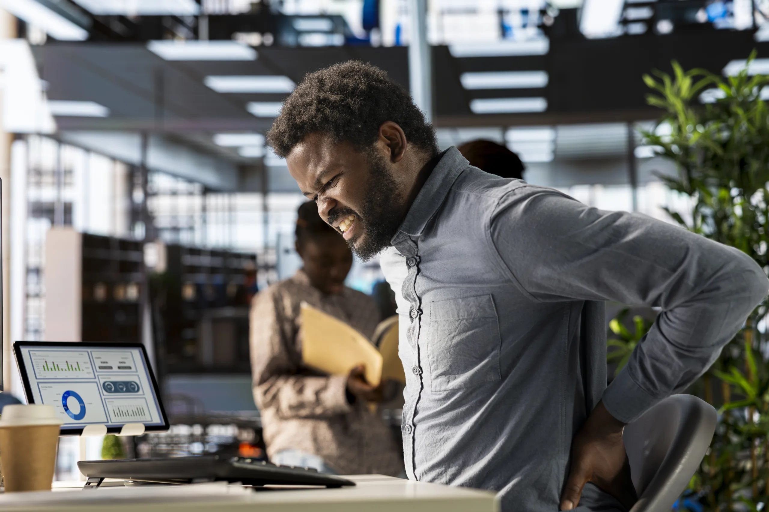 african american business analyst deals with back pain muscle cramps scaled