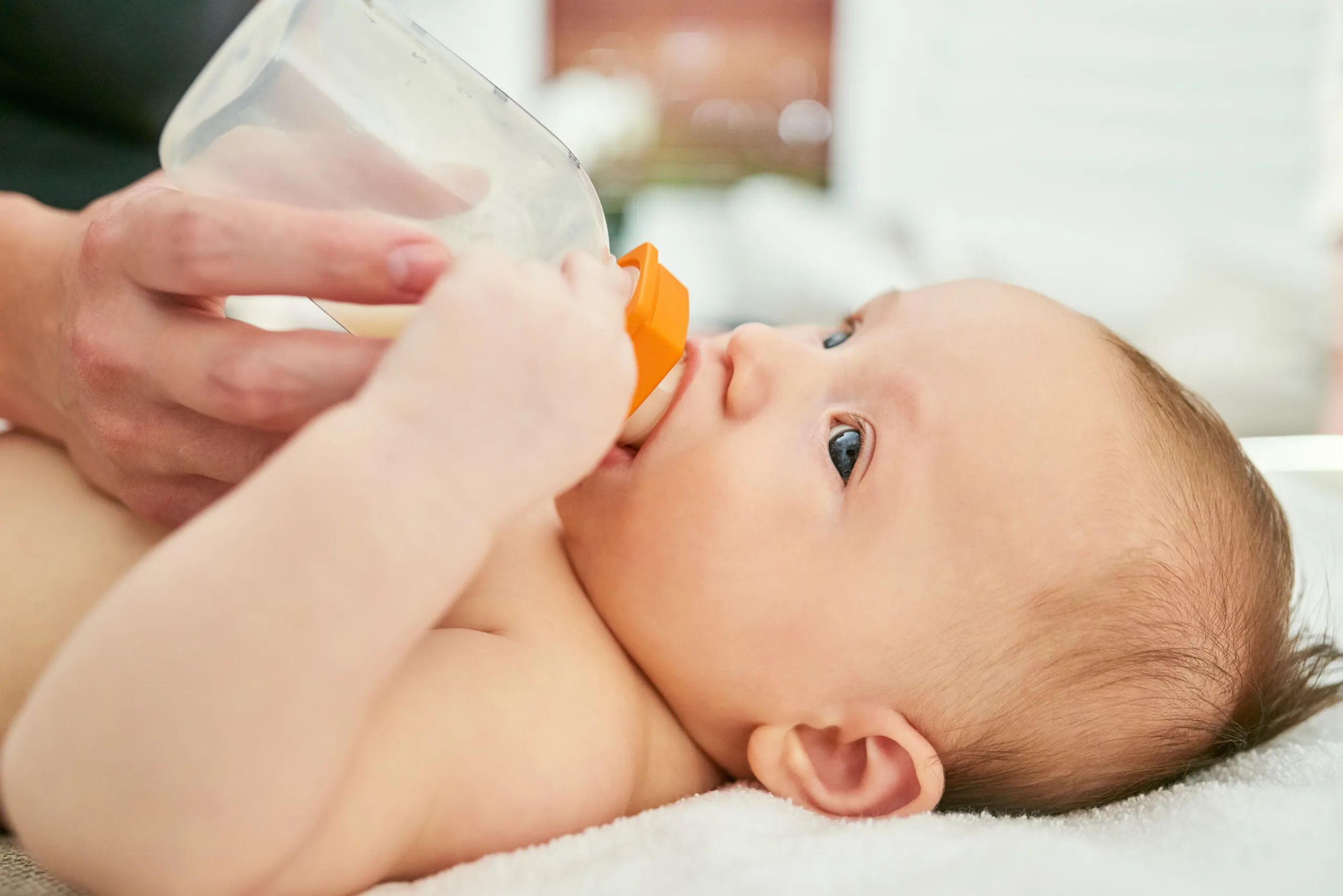 baby hands milk bottle nursery with formula nutrition feeding routine breakfast morning person child drinking family support food health growth development house scaled