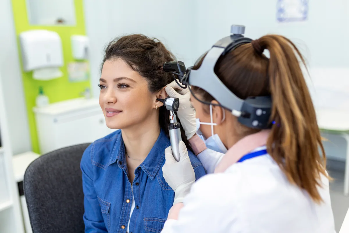 hearing exam otolaryngologist doctor checking woman s ear using otoscope auriscope medical clinic otorhinolaryngologist pulling ear with hand looking it with otoscope closeup