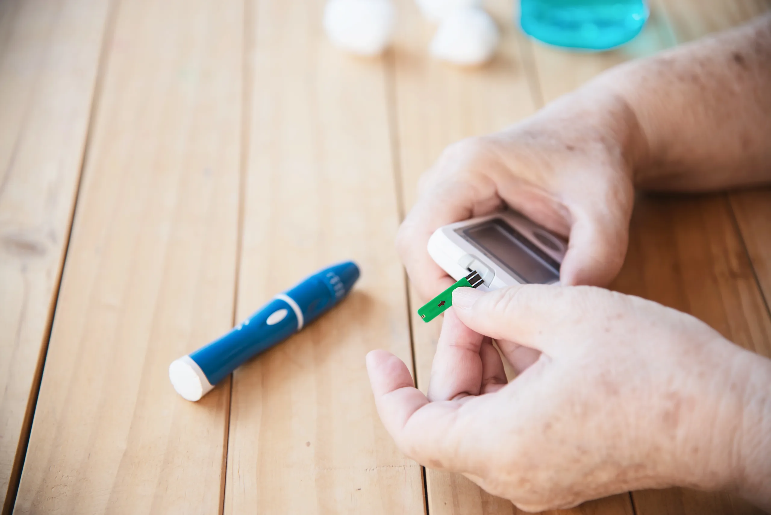old lady is testing blood sugar level using blood sugar test kid set scaled