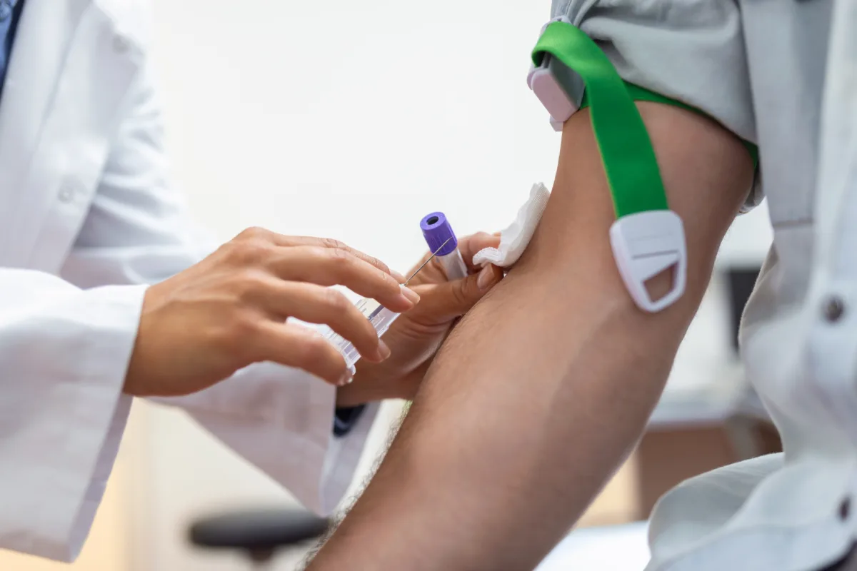preparation blood test by female doctor medical uniform table white bright room nurse pierces patient s arm vein with needle blank tube