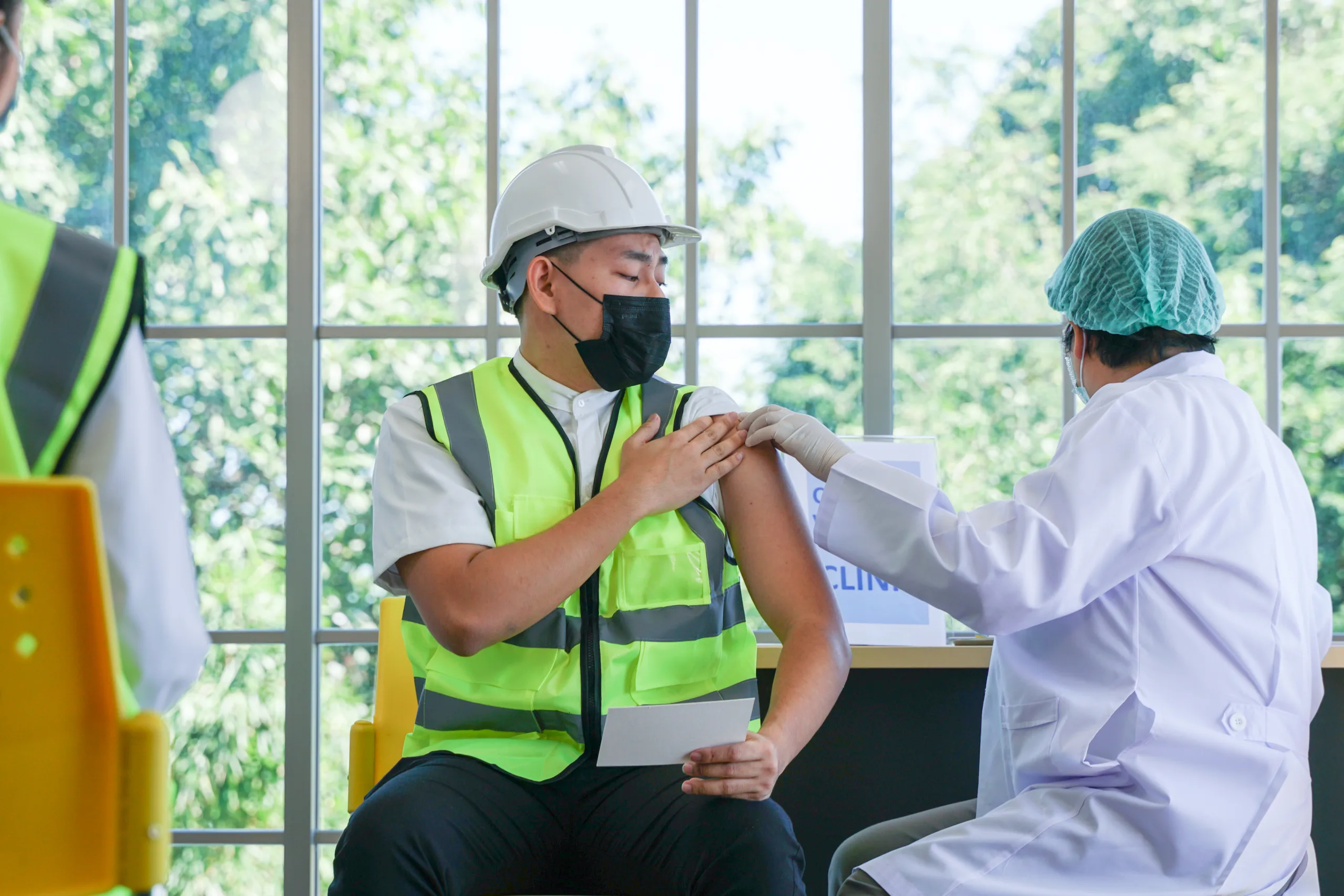 worker man sitting getting covid vaccine with nurse injecting vaccine get immunity scaled