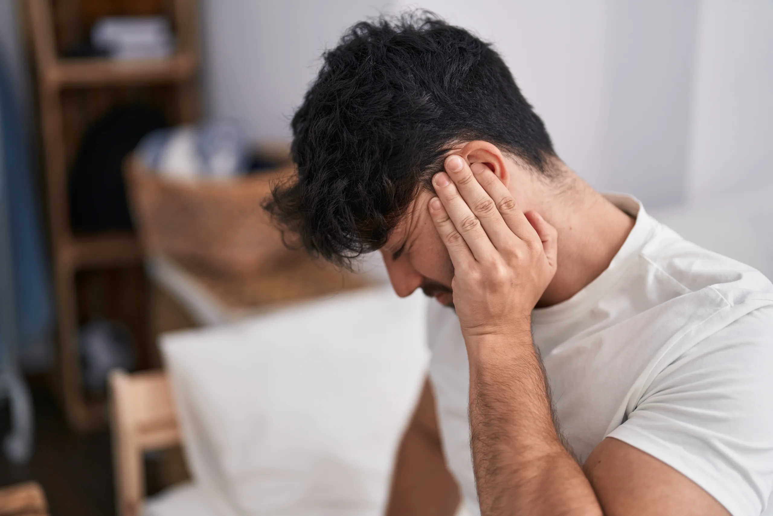 young hispanic man suffering backache sitting bed bedroom scaled