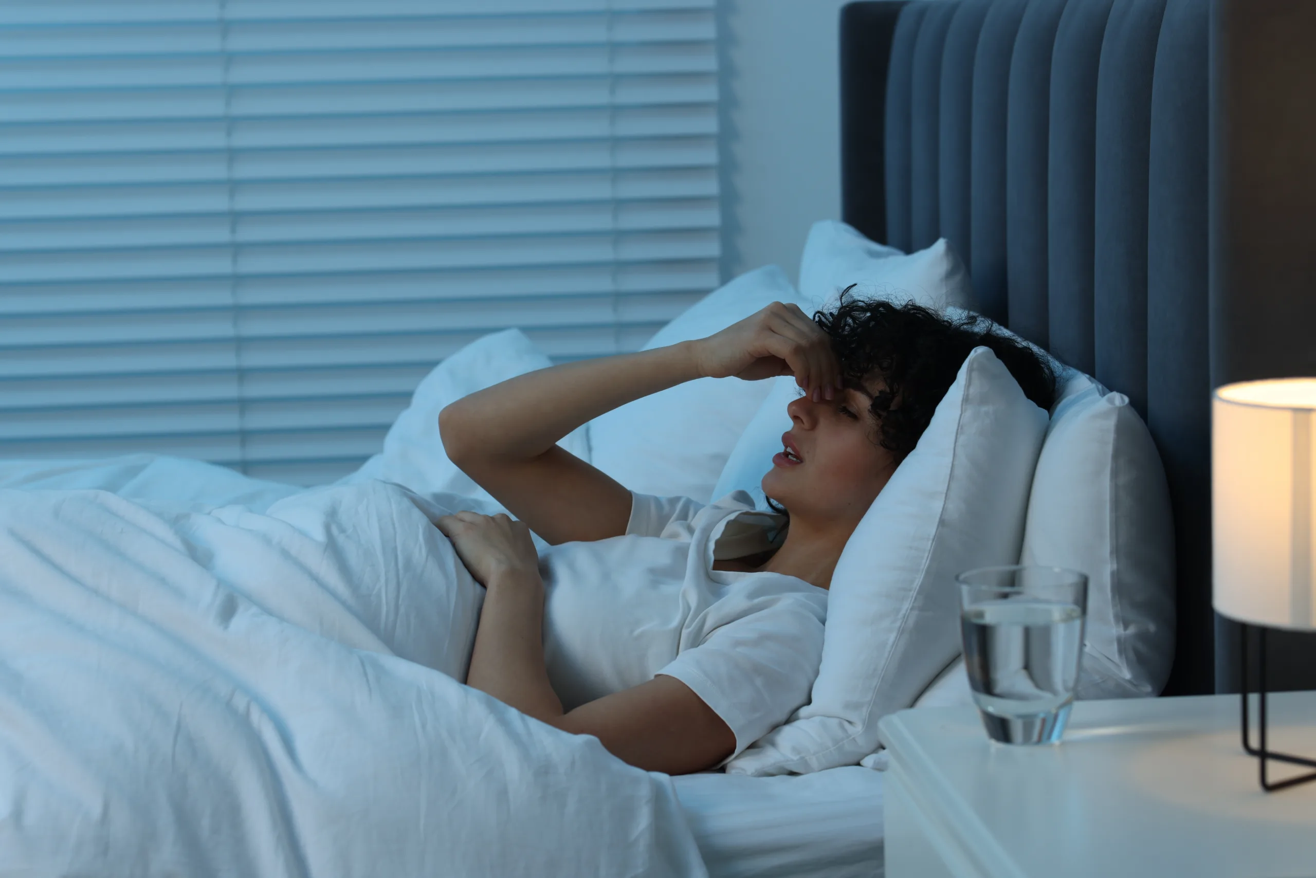 young woman suffering from headache bed night scaled